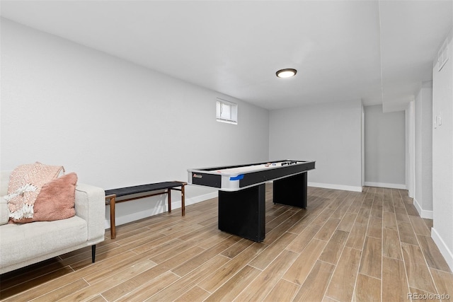 recreation room featuring baseboards and light wood-style floors