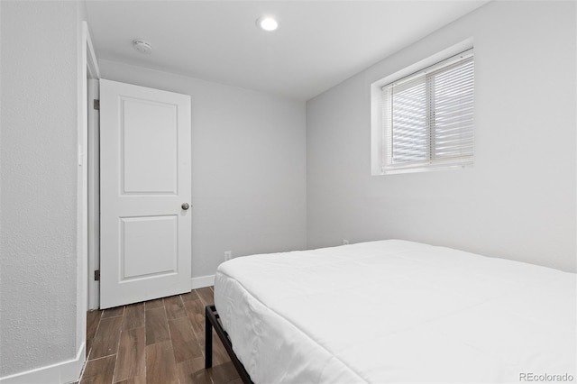 bedroom with baseboards, dark wood-style floors, and recessed lighting