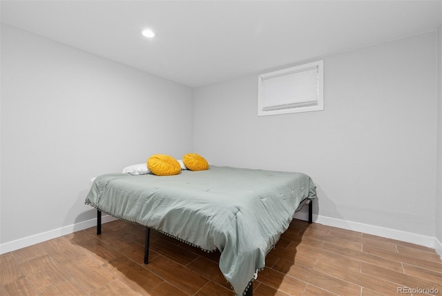 bedroom with recessed lighting, wood finished floors, and baseboards