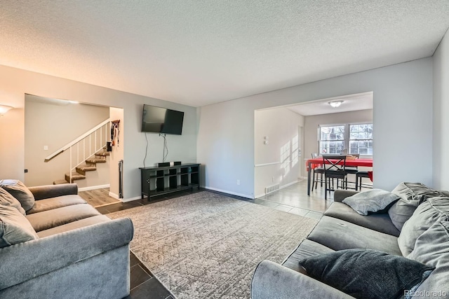 tiled living room featuring a textured ceiling