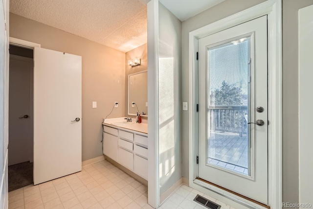 bathroom with a textured ceiling and vanity