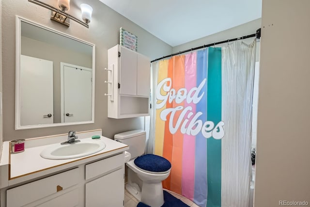 bathroom featuring toilet, vanity, and a shower with curtain