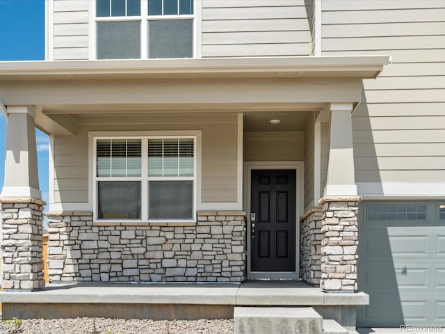 entrance to property with a garage and a porch