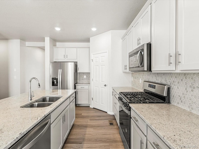 kitchen featuring sink, stainless steel appliances, and white cabinetry