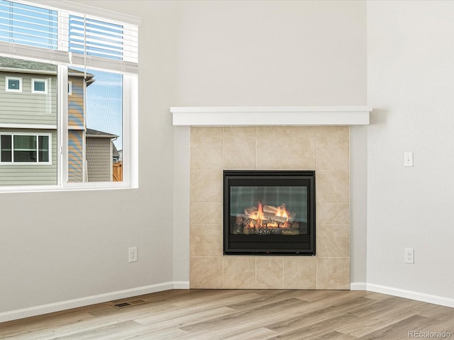 details featuring wood-type flooring and a tile fireplace