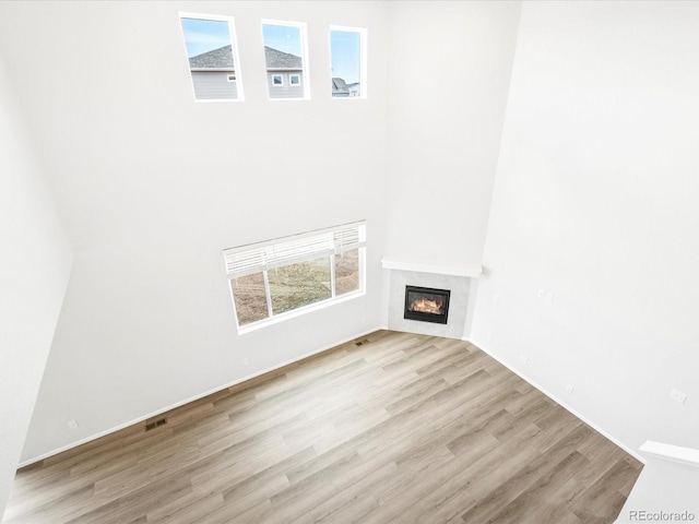 unfurnished living room featuring a healthy amount of sunlight and light hardwood / wood-style floors