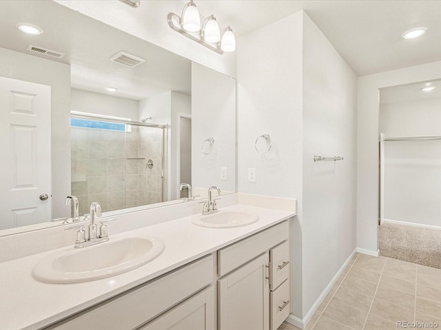 bathroom with an enclosed shower, vanity, and tile patterned floors