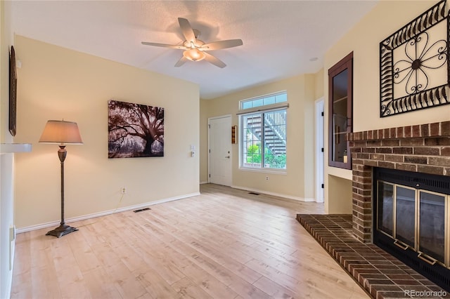 3040 W Prentice Ave Unit B, Littleton, CO 80123 - unfurnished living room with a ceiling fan, a brick fireplace, and wood finished floors