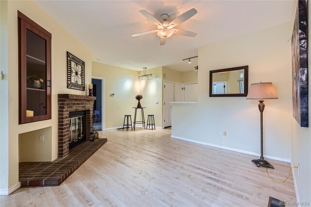 3040 W Prentice Ave Unit B, Littleton, CO 80123 - unfurnished living room with wood finished floors, a ceiling fan, and a brick fireplace
