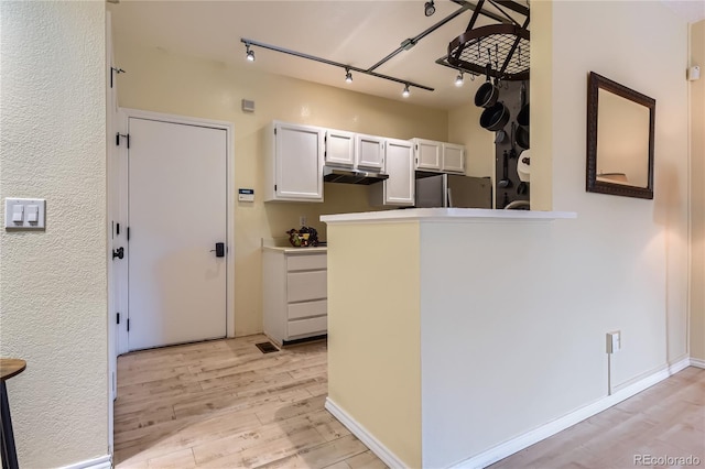 3040 W Prentice Ave Unit B, Littleton, CO 80123 - kitchen featuring freestanding refrigerator, light wood finished floors, rail lighting, white cabinets, and under cabinet range hood