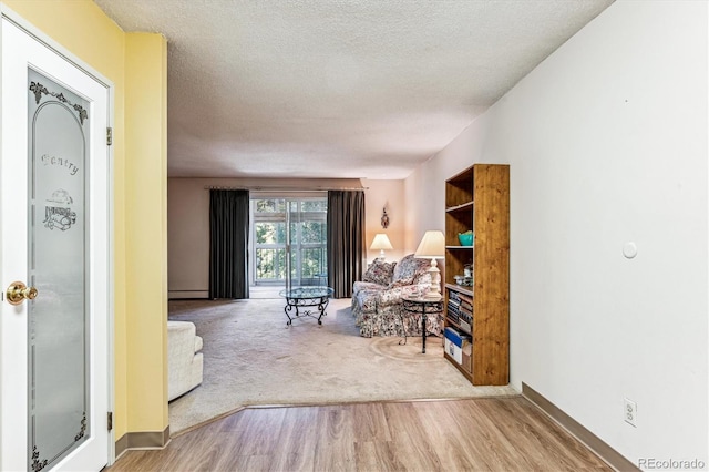 interior space with a textured ceiling and light hardwood / wood-style floors