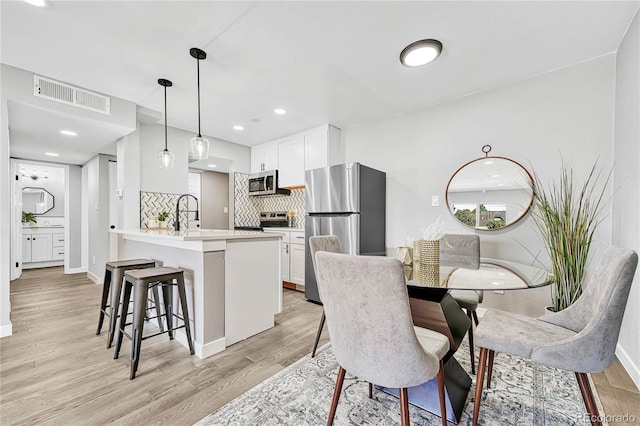 dining space featuring light hardwood / wood-style floors and sink