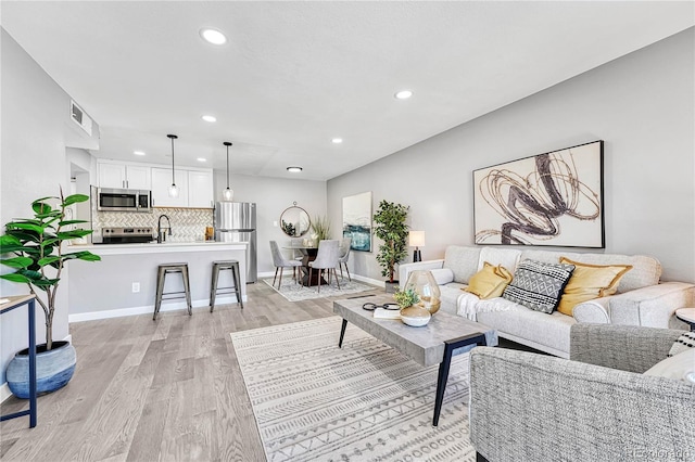 living room featuring light hardwood / wood-style floors and sink