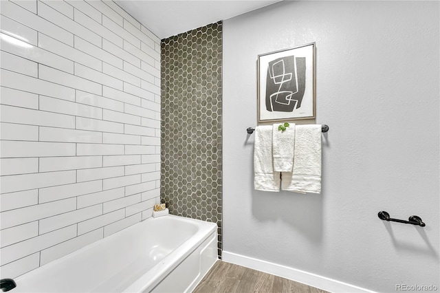 bathroom with hardwood / wood-style flooring and tiled shower / bath