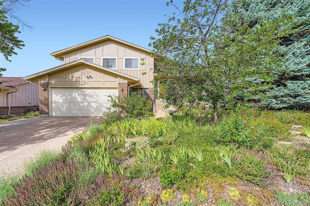 13934 W Warren Dr, Lakewood, CO 80228 - view of front of home featuring concrete driveway, brick siding, board and batten siding, and an attached garage