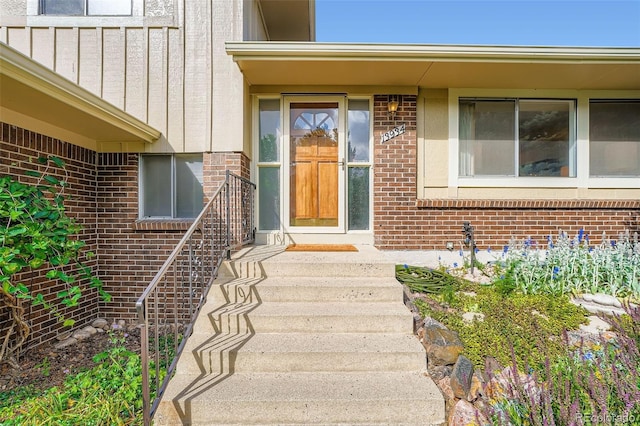 13934 W Warren Dr, Lakewood, CO 80228 - doorway to property with board and batten siding and brick siding
