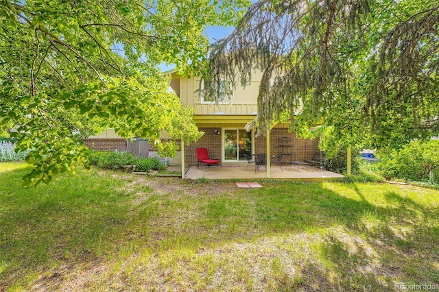 13934 W Warren Dr, Lakewood, CO 80228 - rear view of property with brick siding, a patio area, and a yard
