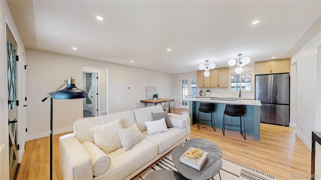 living room featuring sink and light hardwood / wood-style flooring