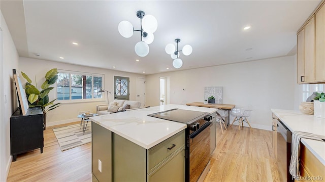 kitchen featuring green cabinetry, decorative light fixtures, light wood-type flooring, electric range, and stainless steel dishwasher