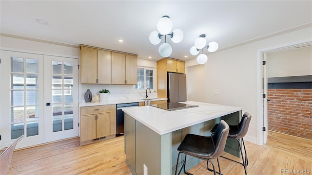 kitchen featuring sink, stainless steel appliances, light brown cabinets, a kitchen island, and light wood-type flooring