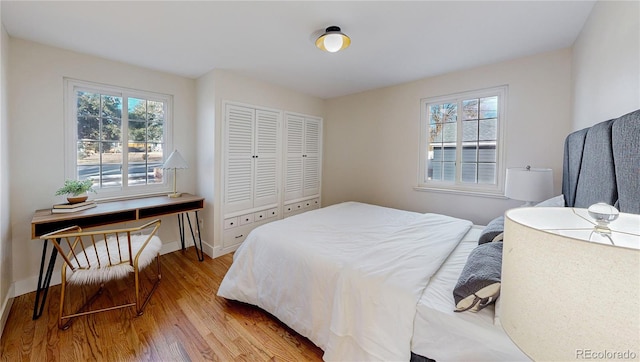 bedroom featuring multiple windows, a closet, and light hardwood / wood-style flooring