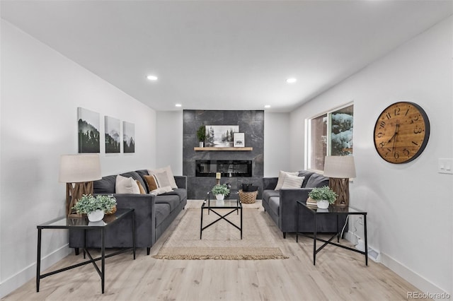 living room with light hardwood / wood-style floors and a tile fireplace