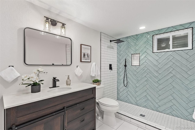 bathroom featuring tiled shower, tile patterned floors, vanity, and toilet