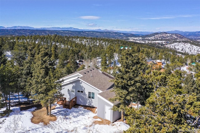 drone / aerial view with a mountain view and a view of trees