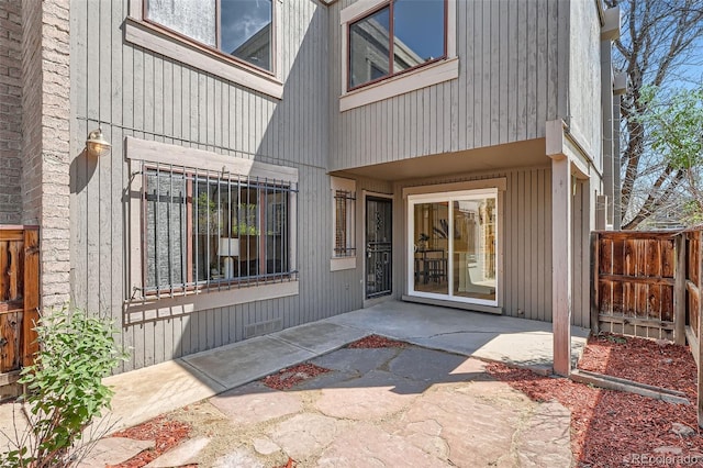 doorway to property featuring fence and a patio area