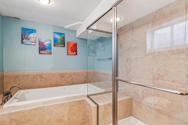 bathroom with plus walk in shower and a textured ceiling