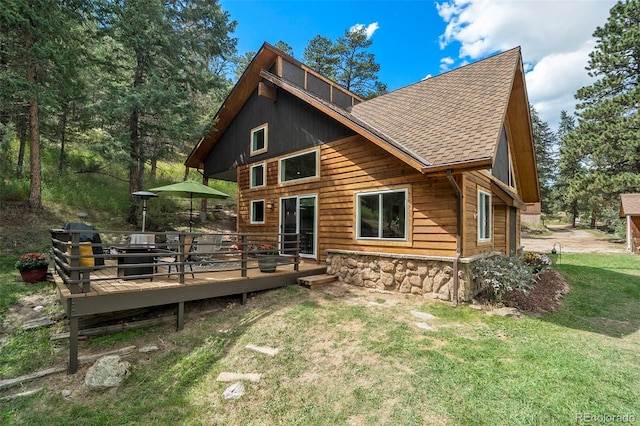 back of property with a wooden deck and a yard