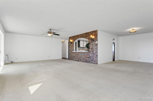 unfurnished living room featuring carpet floors and ceiling fan