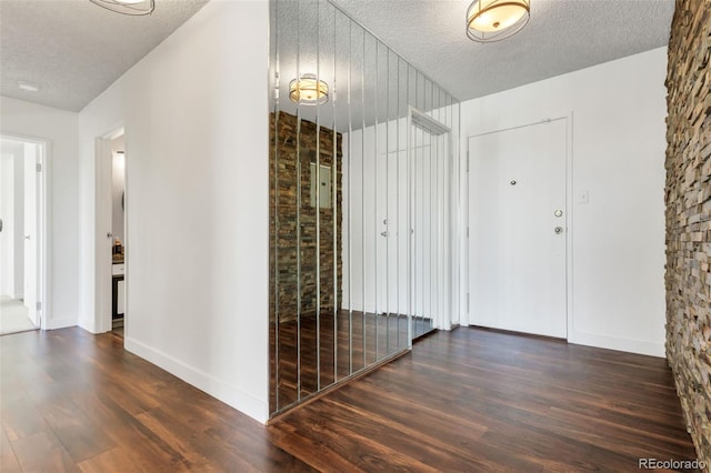 entryway with a textured ceiling and dark hardwood / wood-style flooring