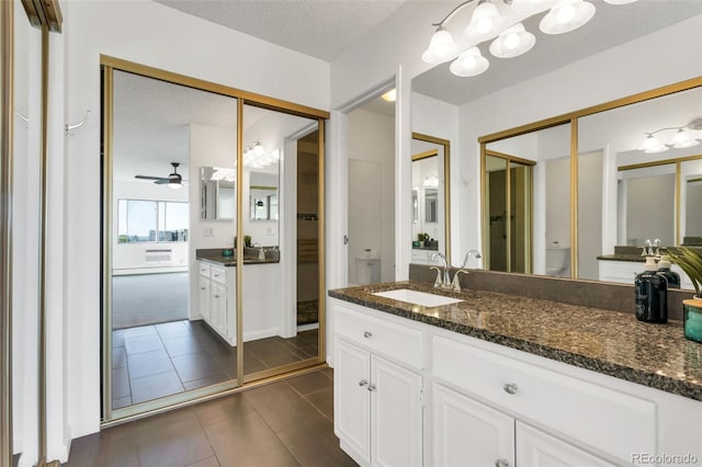 bathroom featuring ceiling fan, tile patterned flooring, vanity, a textured ceiling, and toilet