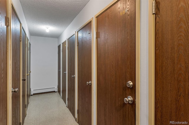 hallway featuring a baseboard radiator and a textured ceiling