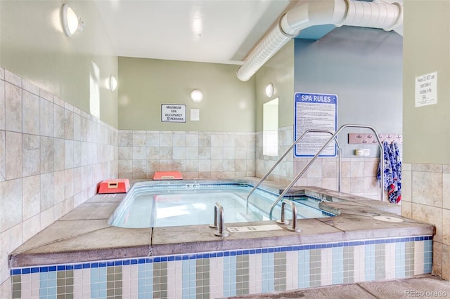 view of swimming pool with an indoor hot tub