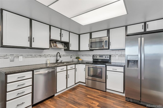 kitchen featuring sink, tasteful backsplash, dark hardwood / wood-style flooring, stainless steel appliances, and white cabinets