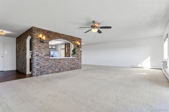 unfurnished living room with ceiling fan, carpet, and a textured ceiling