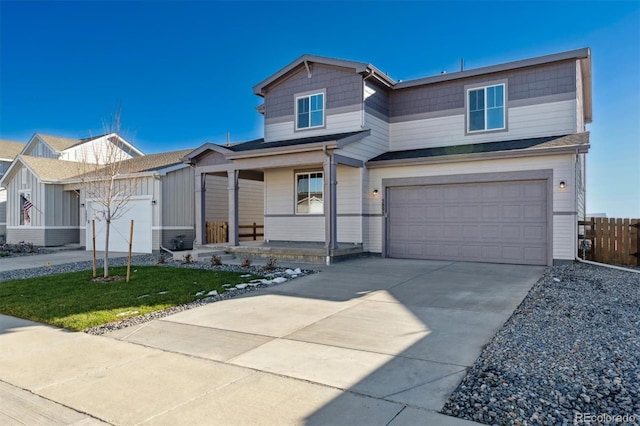 view of front of property featuring a garage, covered porch, and a front yard