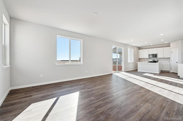 unfurnished living room with dark hardwood / wood-style flooring