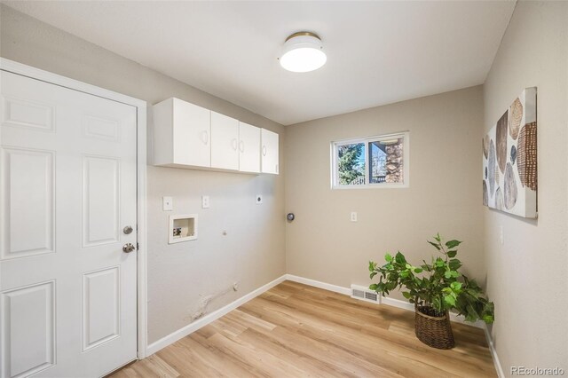 washroom with cabinets, electric dryer hookup, gas dryer hookup, hookup for a washing machine, and light hardwood / wood-style floors