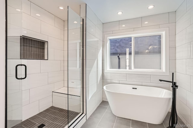 bathroom featuring tile walls, tile patterned floors, and separate shower and tub