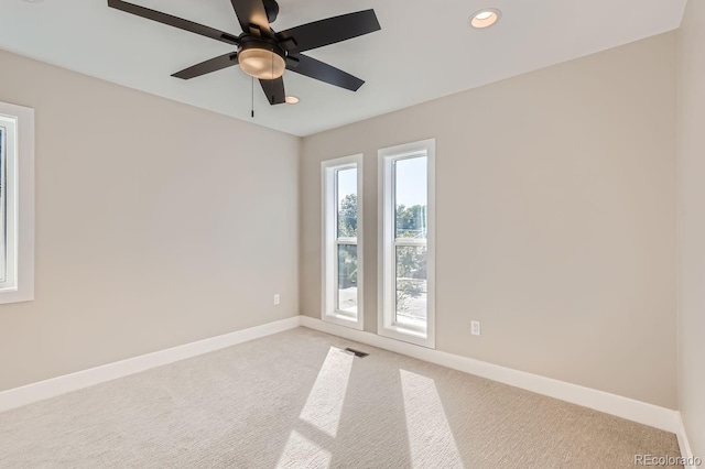 carpeted spare room featuring ceiling fan