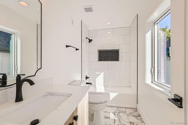 full bathroom featuring toilet, tiled shower / bath, and vanity