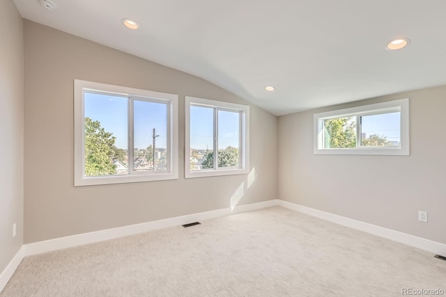 carpeted empty room featuring vaulted ceiling