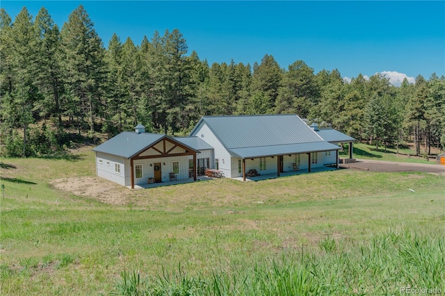 19745 Hopi Pines Grv, Peyton, CO 80831 - view of front of property featuring covered porch, a front yard, and a wooded view