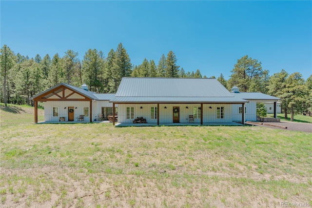 19745 Hopi Pines Grv, Peyton, CO 80831 - view of front of house featuring covered porch, board and batten siding, and a front lawn