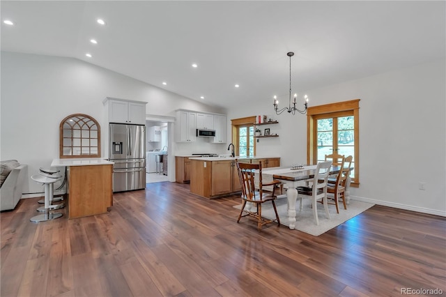 19745 Hopi Pines Grv, Peyton, CO 80831 - dining space featuring a chandelier, dark wood-type flooring, recessed lighting, and high vaulted ceiling