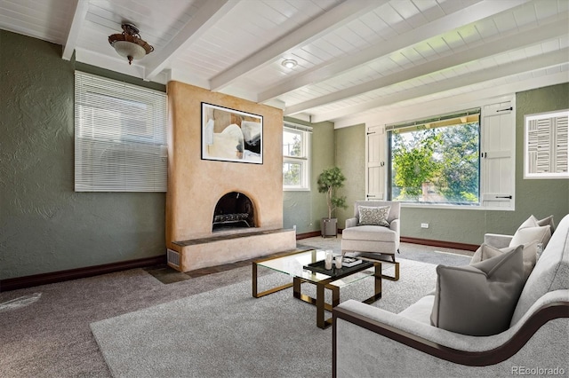 living room featuring carpet floors, beamed ceiling, and a fireplace