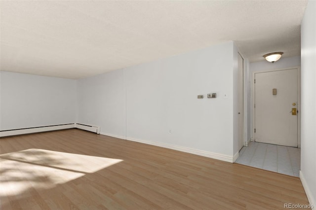 unfurnished room with a textured ceiling and light wood-type flooring